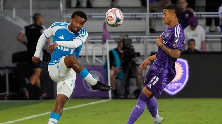 Charlotte FC defender Nathan Byrne, left, passes the ball over...