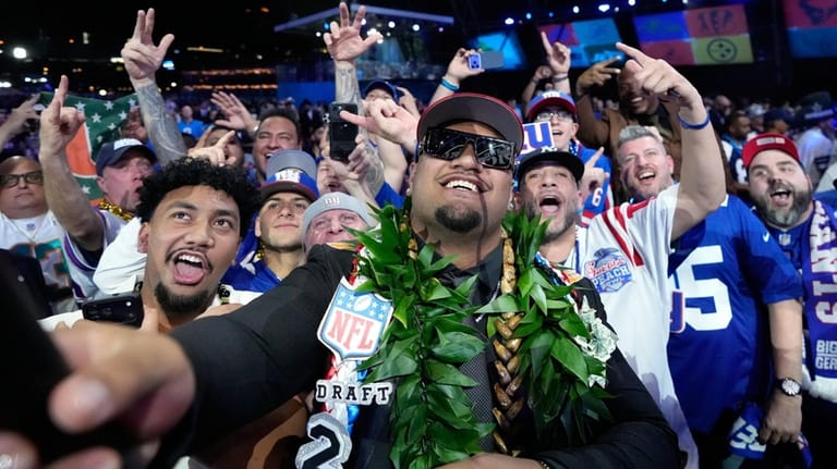 Miami offensive lineman Francis Mauigoa celebrates with fans after being...
