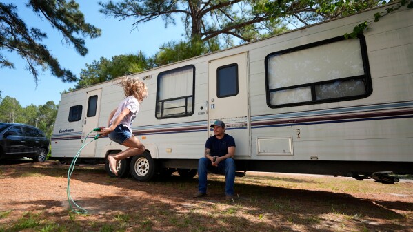 Annabelle Enke plays as her father Michael Gibson looks on after losing thier home at the Brantley Highway 82 fire, Friday, April 24, 2026, in Nahunta, Ga. (AP Photo/Mike Stewart)