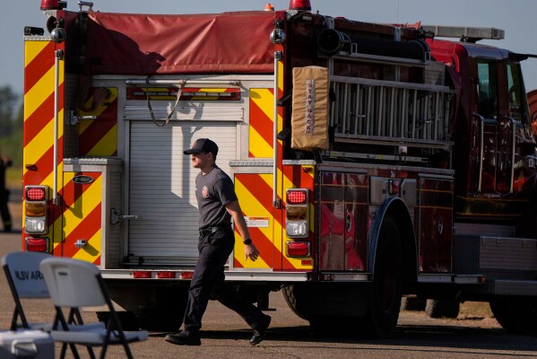 Fire crews and truck assemble at the Brantley County Airport as they work the Brantley highway 82 fire, Thursday, April 23, 2026, near Nahunta, Ga. (AP Photo/Mike Stewart)