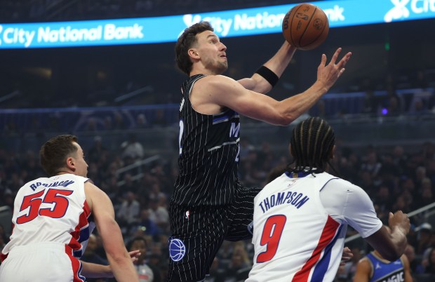 Orlando forward Franz Wagner (22) goes up to score over Detroit guard Duncan Robinson (55) and Detroit forwrard Ausar Thompson (9) during the NBA Playoff Game 3 of Detroit Pistons at Orlando Magic at the Kia Center on Saturday, April 25, 2026. Orlando won the game 113-105 to go up 2-1 in the series. (Stephen M. Dowell/Orlando Sentinel)