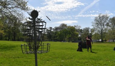 Chains of Command Disc Golf Club founder Scott Frazier tosses a disc into a basket at Foreman's Grove Disc Golf Course. Foreman hopes that the club encourages more people to give the sport a try and make the city a disc golf destination.