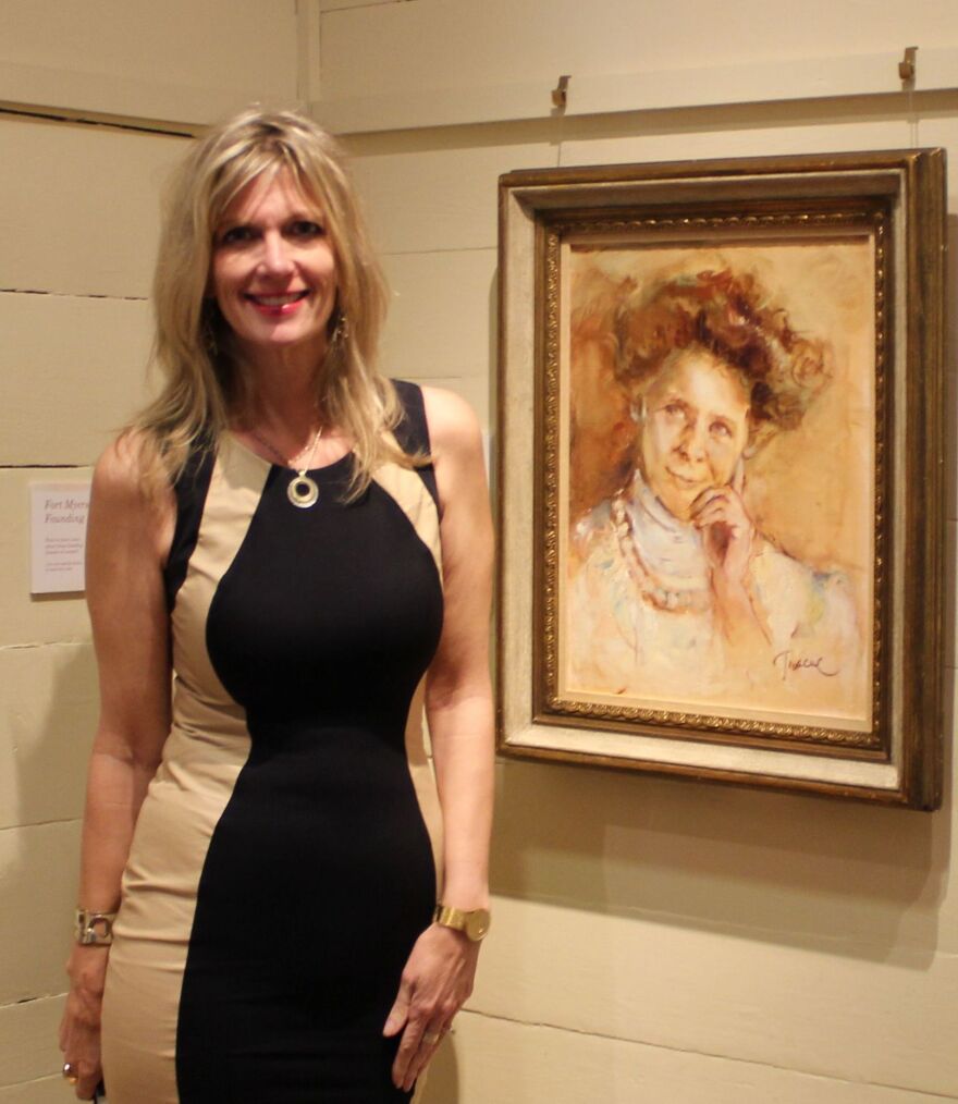 Impressionist artist Tracy Owen Cullimore poses adjacent to her portrait of Fort Myers female pioneer Flossie Hill.