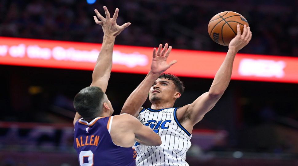 Phoenix Suns forward Royce O'Neale (00) goes up to shoot as Orlando Magic forward Jamal Cain (8) defends during the first half of an NBA basketball game, Tuesday, March 31, 2026, in Orlando, Fla. (AP Photo/Phelan M. Ebenhack)