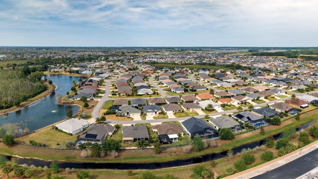 Aerial view of a residential community in Ocala, Florida, featuring houses, roads, ponds, and trees.