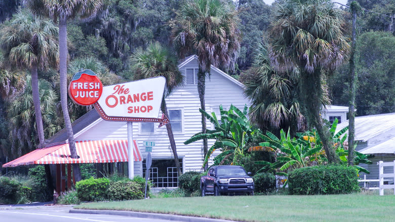 Outside of the famous Orange Shop in Citra with its big sign and surrounding palm trees.