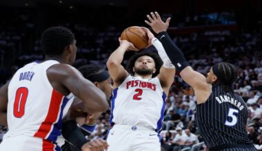 Detroit Pistons guard Cade Cunningham (2) takes a shot against Orlando Magic forward Paolo Banchero (5) as Pistons center Jalen Duren (0) helps defend during the first half in Game 2 of a first-round NBA basketball playoffs series Wednesday, April 22, 2026, in Detroit. (AP Photo/Duane Burleson)