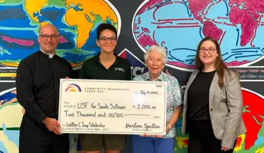 Student receives scholarship check from Community Foundation Tampa Bay with family and presenters