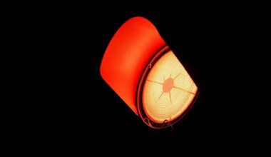 An extreme close-up photograph of a damaged traffic signal light against a pitch-black background, lit by a harsh, direct camera flash, conceptually representing the safety challenges facing Florida