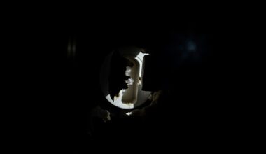An extreme close-up photograph of a damaged lock or broken security device, capturing the stark, gritty aftermath of a commercial burglary in dramatic lighting.