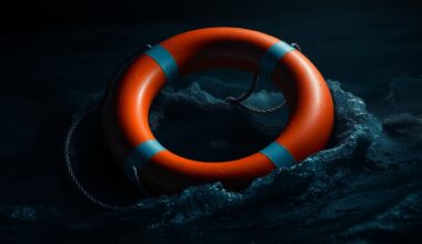An extreme close-up photograph of a bright orange life preserver ring floating in dark, choppy waters, the harsh flash illuminating the textured surface of the ring against the inky blackness of the background, conveying a sense of urgency and peril.