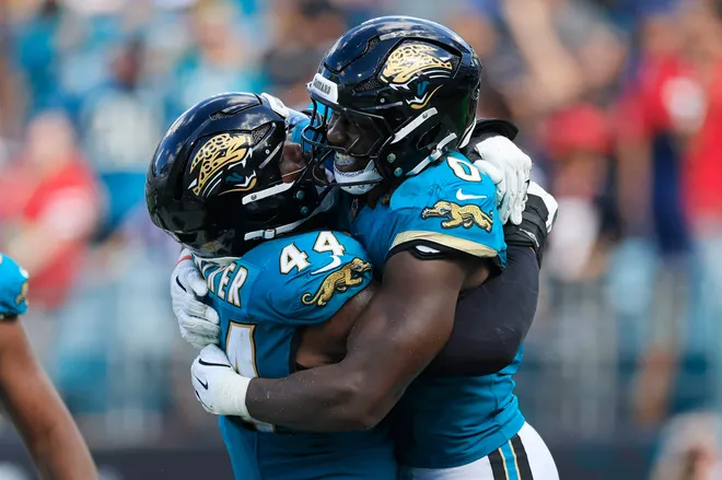 Jacksonville Jaguars defensive end Travon Walker (44) hugs linebacker Devin Lloyd (0) after picking up a fumble recovery during the fourth quarter of an NFL football matchup at EverBank Stadium, Sunday, Sept. 21, 2025, in Jacksonville, Fla. The Jaguars defeated the Texans 17-10.