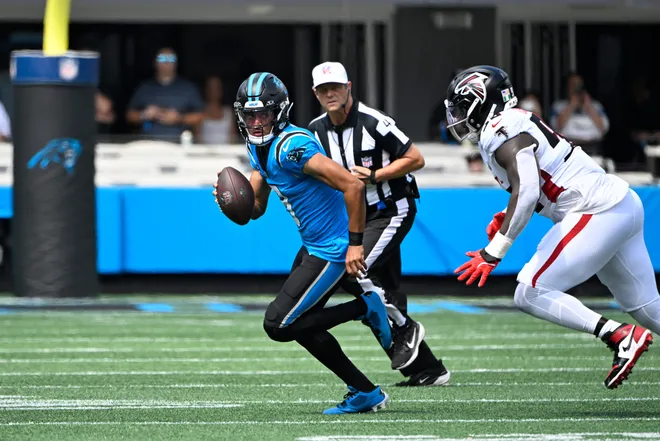 Sep 21, 2025; Charlotte, North Carolina, USA; Carolina Panthers quarterback Bryce Young (9) with the ball as Atlanta Falcons defensive tackle Ruke Orhorhoro (98) defends in the first quarter at Bank of America Stadium. Mandatory Credit: Bob Donnan-Imagn Images