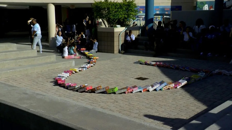 Students cheered as each cereal box fell, creating a successful domino run as boxes cascaded down two floors and throughout the school.