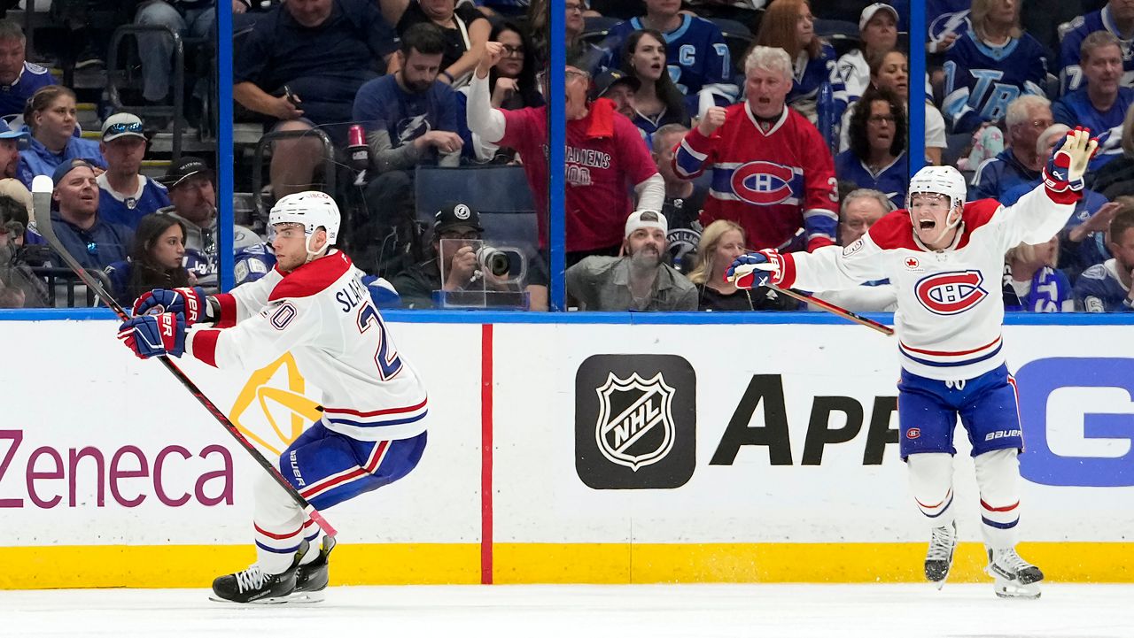 Montreal Canadiens left wing Juraj Slafkovsky (20) celebrates his goal with right wing Cole Caufield against the Tampa Bay Lightning during overtime in Game 1 of an NHL hockey Stanley Cup first-round playoff series, Sunday, April 19, 2026, in Tampa, Fla. (AP Photo/Chris O'Meara)