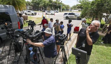 Members of the media document detectives and deputies with the Hillsborough County Sheriff's Office as they investigate inside the Lake Forest subdivision of Tampa, Fla., on Friday, April 24, 2026, where authorities said a man was taken into custody after barricading himself inside a home, in connection to the search for two missing University of South Florida graduate students. (Douglas R. Clifford/Tampa Bay Times via AP)