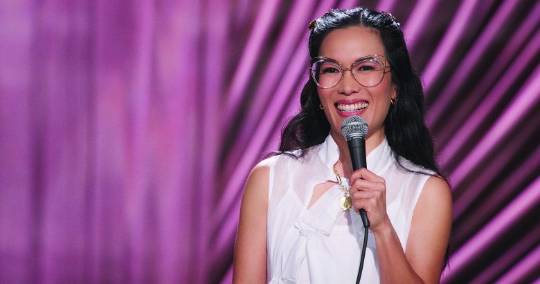 Ali Wong smiling and holding a mic in front of a purple background in her "Ali Wong: Single Lady" Netflix standup special