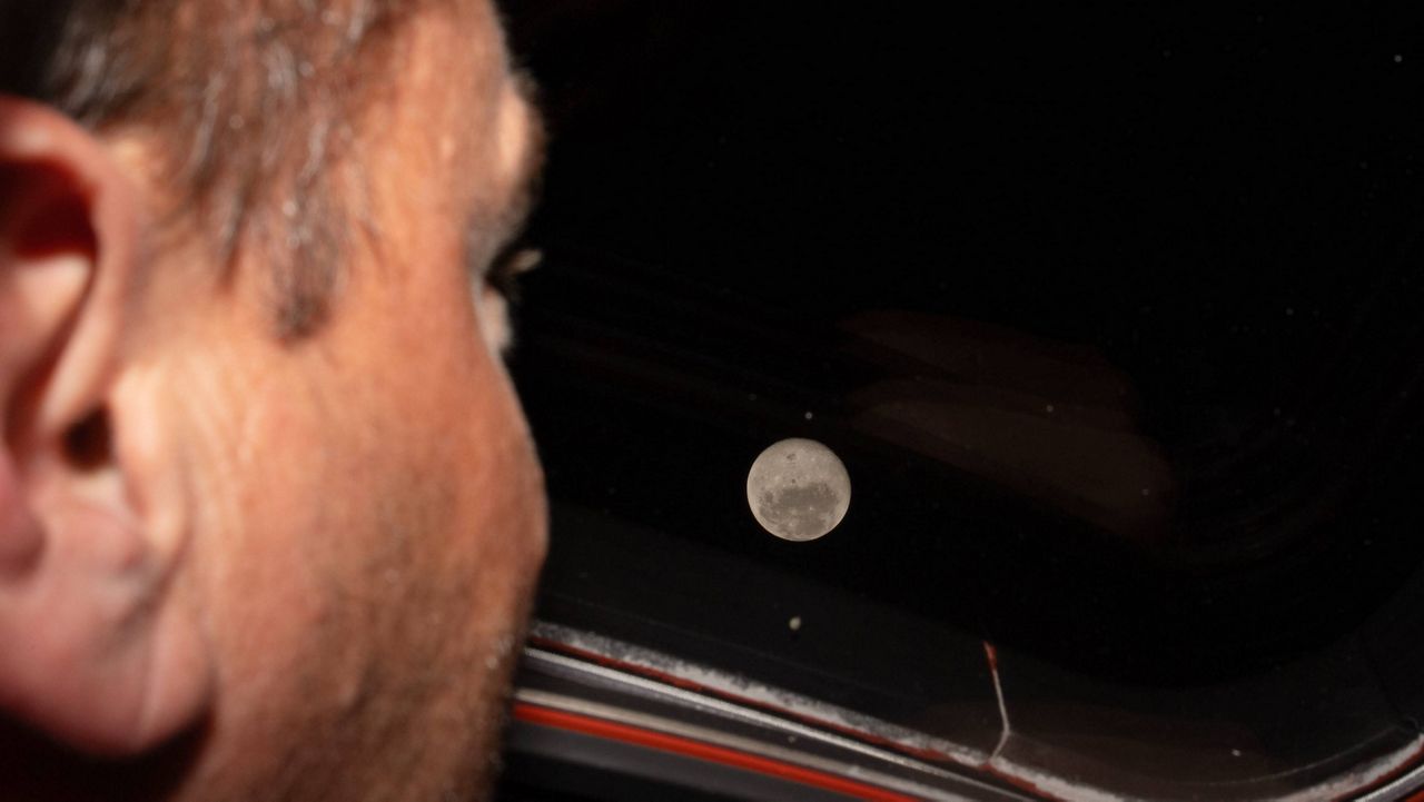 Artemis II commander and NASA astronaut Reid Wiseman looks out one of the Orion spacecraft's main cabin windows at the Moon ahead of the crew's lunar flyby on April 6, 2026. (NASA via AP)