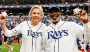 Tampa Mayor Jane Castor and St. Petersburg Mayor Ken Welch hold baseballs on the field at a Tampa Bay Rays game