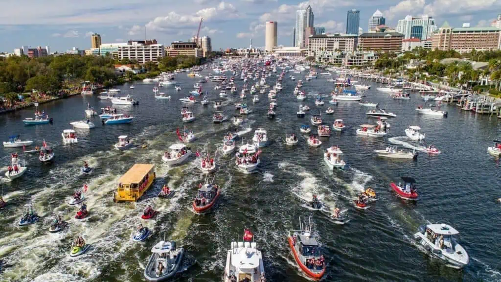 aerial view of a boat parade with multiple small vessels decorated for the 4th of July