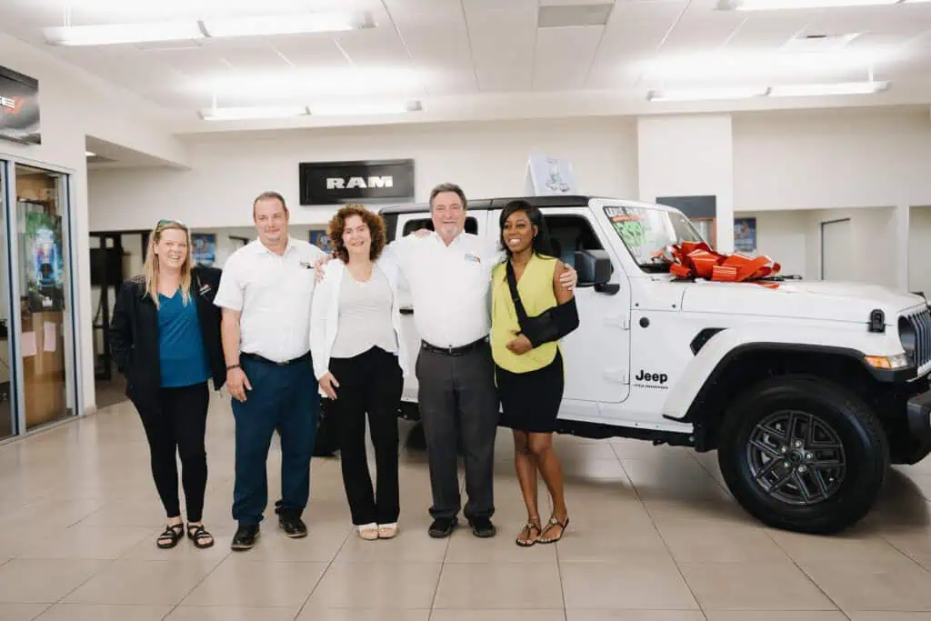 People standing at a car dealership