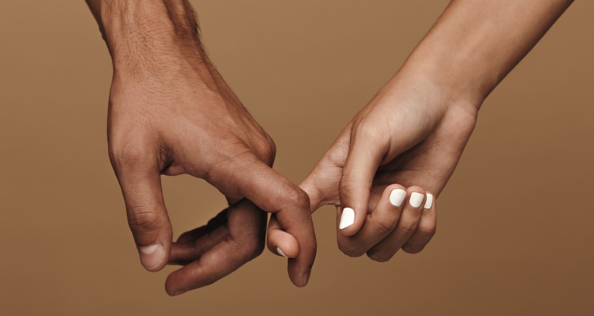 Close-up photo of a couple linking index fingers