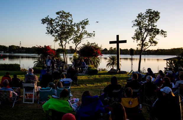 People gather at sunrise for a church service during the ninth annual Easter Eat, Pray, Swim event at Lucky's Lake Swim in Orlando in 2019. (Patrick Connolly/Orlando Sentinel)