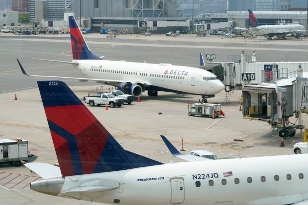 Delta Air Lines passenger jets rest on an airport tarmac. The Atlanta-based carrier, which maintains a large presence at Fort Lauderdale-Hollywood International Airport, projects fuel prices could soon lift air fares by $15 to $20 a month one way. (AP Photo/Steven Senne)