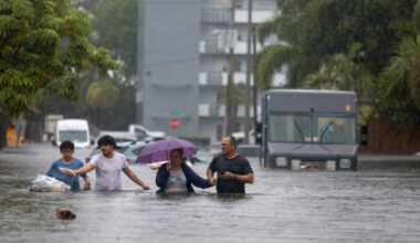 People walk through as flooded street as they evacuate during a storm on June 12, 2024, in Hollywood, Fla. Credit: Joe Raedle/Getty Images