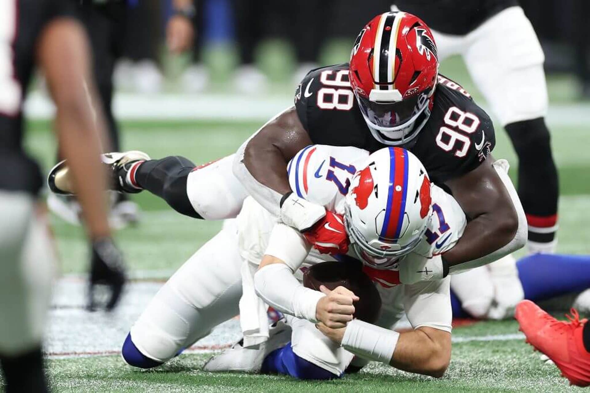 Josh Allen #17 of the Buffalo Bills is tackled by Ruke Orhorhoro #98 of the Atlanta Falcons in the second quarter of the game at Mercedes-Benz Stadium on October 13, 2025, in Atlanta, Georgia.