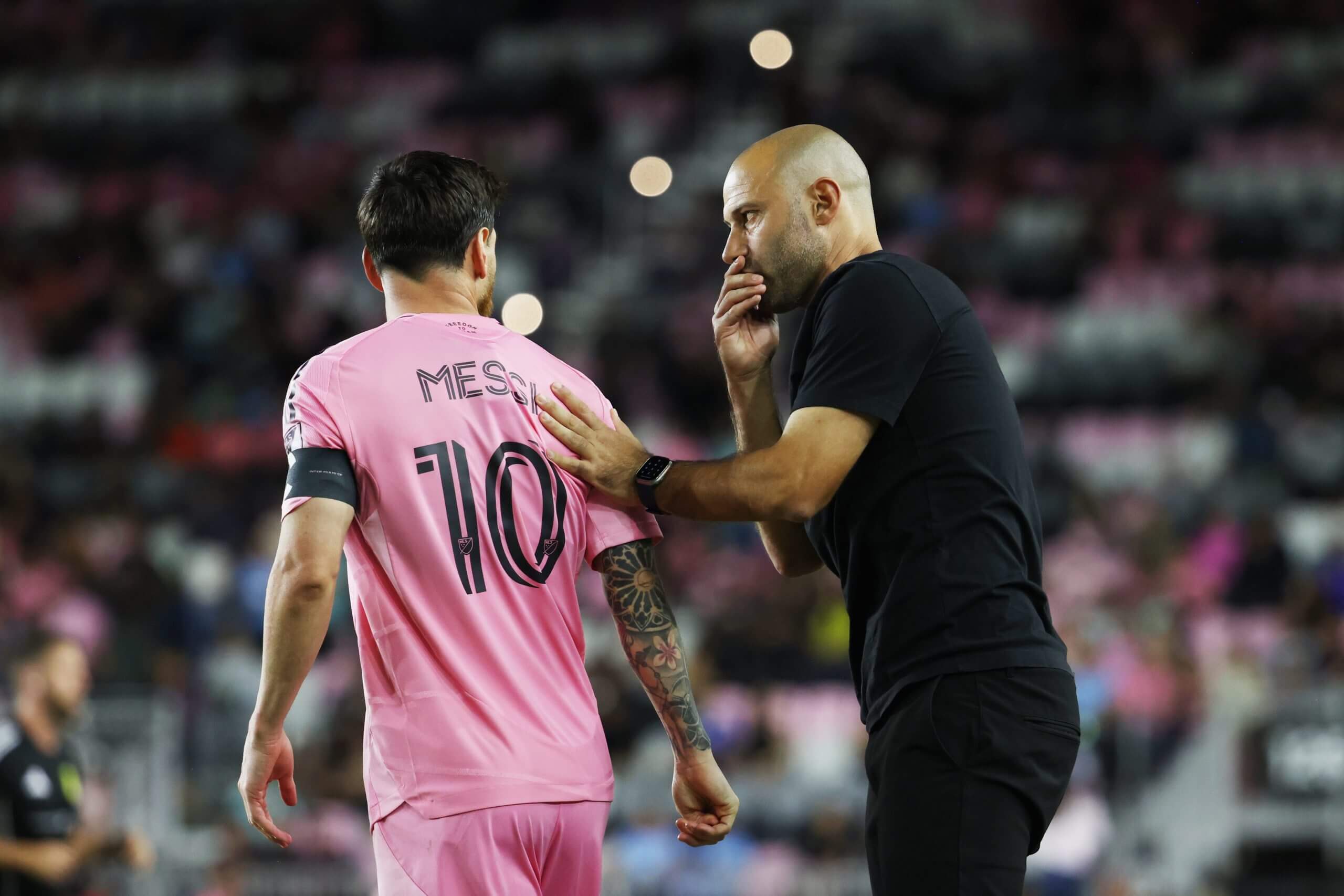 Javier Mascherano gives Lionel Messi instruction