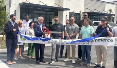 Apopka Mayor Bryan Nelson (center) cuts the ribbon at Lake Carter Exchange during a ceremony April 23 at the mixed-use development on Ocoee-Apopka Road and West Keene Road. Developers and business leaders joined the Apopka Area Chamber of Commerce for the event.