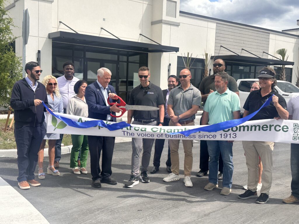 Apopka Mayor Bryan Nelson (center) cuts the ribbon at Lake Carter Exchange during a ceremony April 23 at the mixed-use development on Ocoee-Apopka Road and West Keene Road. Developers and business leaders joined the Apopka Area Chamber of Commerce for the event.