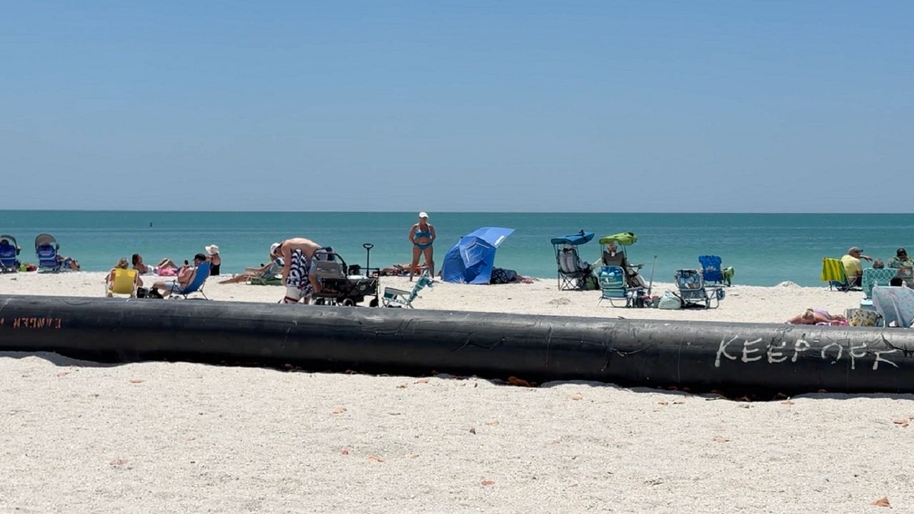 A giant black pipe stretching across Lido Beach is part of a renourishment project, but it is also making things safer for those sailing through the New Pass Channel. (Spectrum News/Claire Alfree)