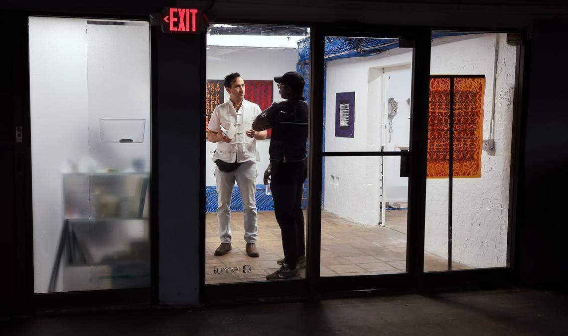 Featured artist Sterling Rook, 42, left, talks with Drew Eccleston, 35, right, as he and other ICA cohorts are given a tour of the Tunnel Projects, a multifaceted art space dedicated to supporting local artists on Saturday, April 11, 2026, in Little Havana, Miami, Florida.