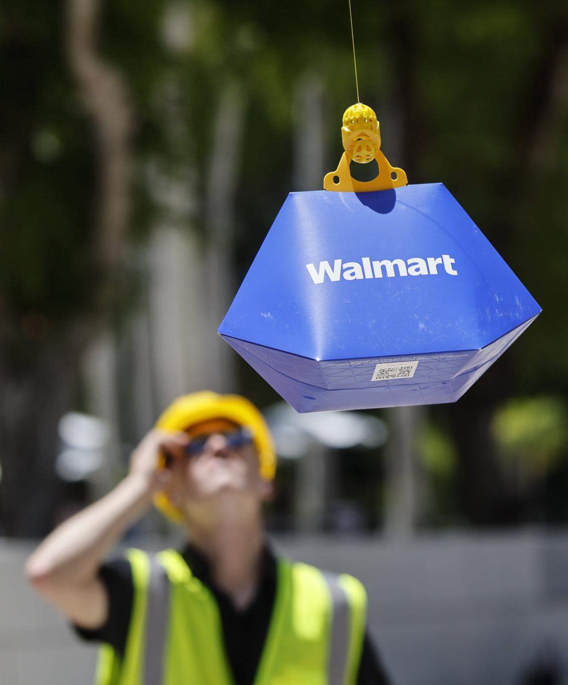 Walmart and Wing demonstrate a drone delivery system during CoMOTION Miami, at Miami Dade College's Wolfson Campus in Miami, Florida, on Tuesday, April 28, 2026. Walmart and Wing expect to launch the new drone delivery service in Miami in 2027 as part of its coast to coast expansion plans. Weighing just over 11 pounds, Wing delivery drones cruise at up to 60 mph about 150 feet above the ground. They then hover at about 23 feet to gently lower orders, ensuring safe delivery without spills or cracks. Walmart products eligible for drone delivery include grocery items, household goods and over-the-counter medicine.