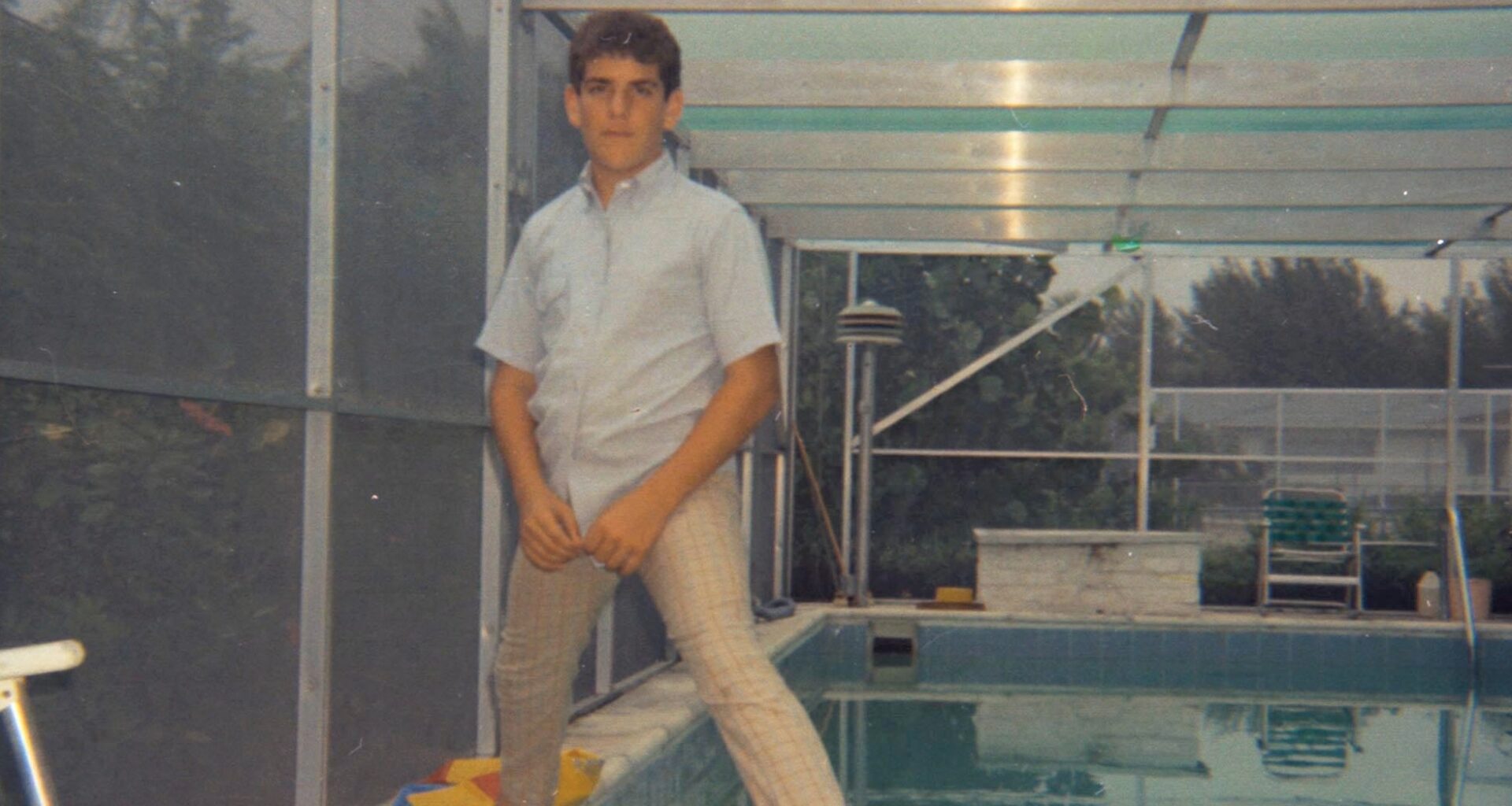 grainy photo of a young boy standing over a pool in the '70s