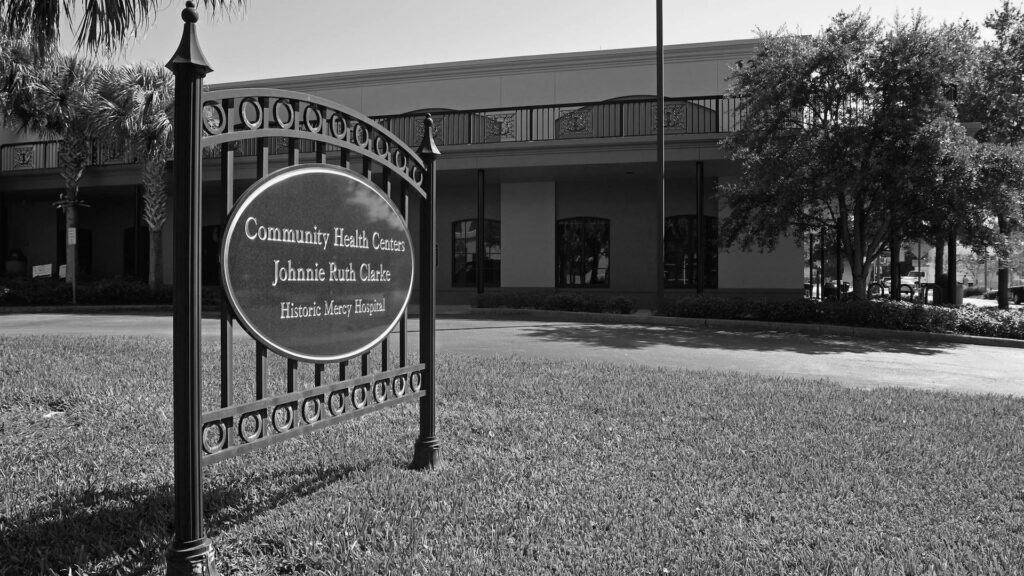 outside a hospital with a marker on the outside. the photo is in black and white