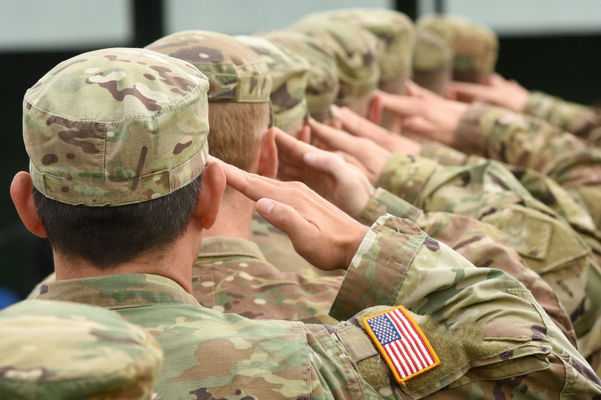 Soldiers in United States military uniforms saluting.