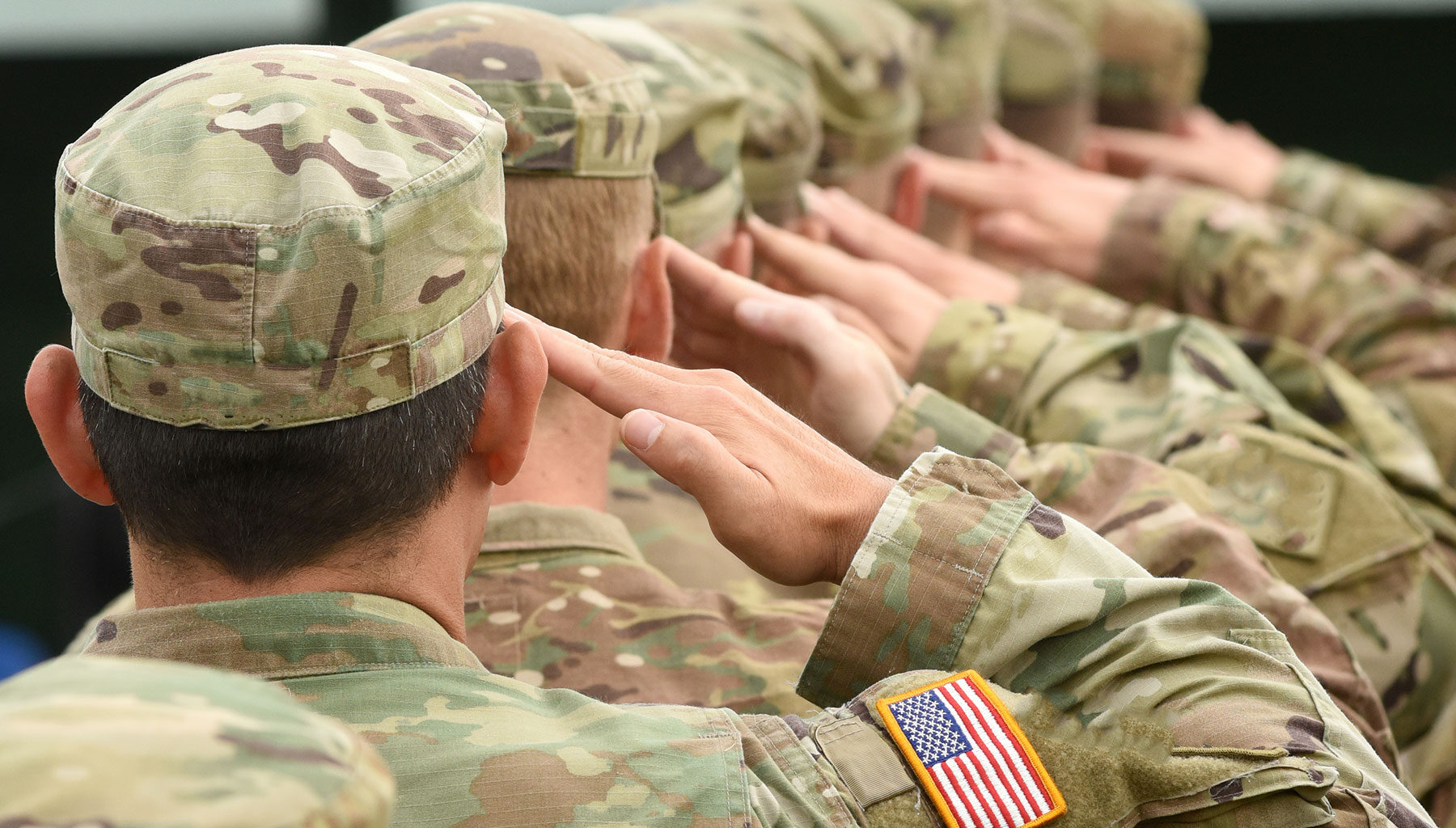 Soldiers in United States military uniforms saluting.