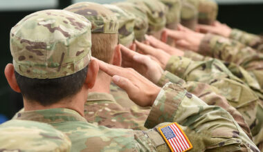 Soldiers in United States military uniforms saluting.