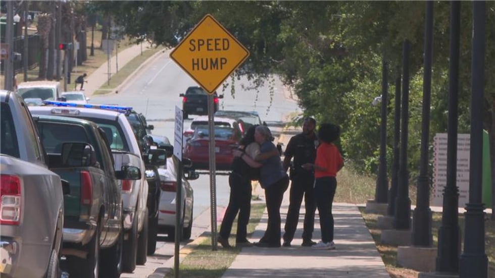 People gather on the sidewalk and hug on FAMU's campus after false reports of a shooter on...