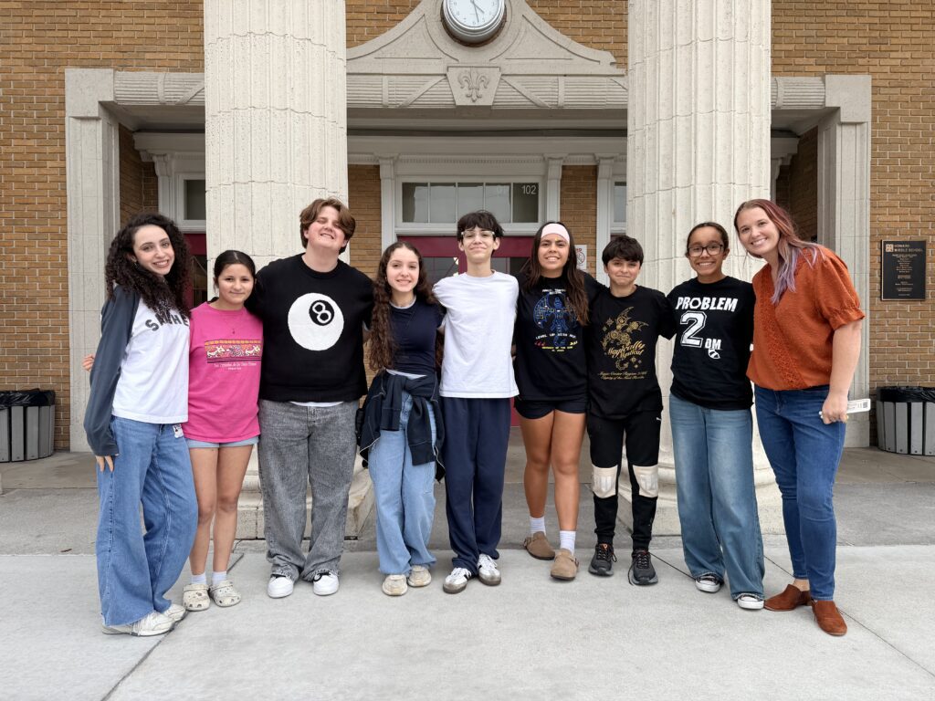 a group of students standing in front of a school