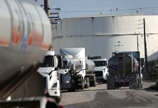 Gasoline tanker trucks wait in line for fuel at Port Everglades on Tuesday, April 18, 2023. Gas deliveries to South Florida have been affected by last week's historic rainfall and flooding.