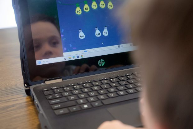 Brooks Bordy works on his school-issued laptop at home on Thursday, April 9, 2026. Months after Broward County Public Schools equipped every student with a personal device, the district is considering whether to rein in technology use due to concerns over excessive screen time. (Mike Stocker/South Florida Sun Sentinel)