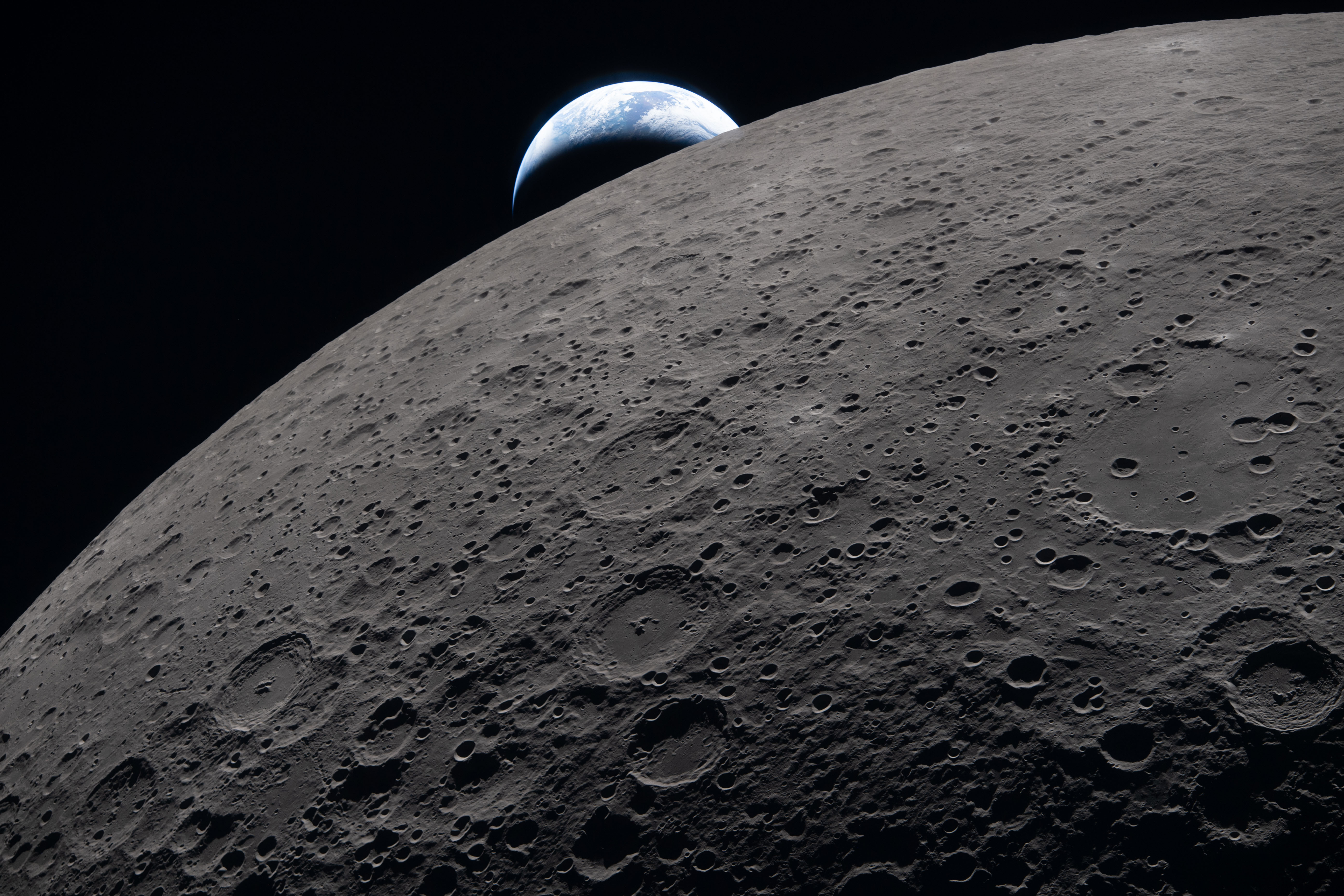 The lunar surface fills the frame in sharp detail, as...