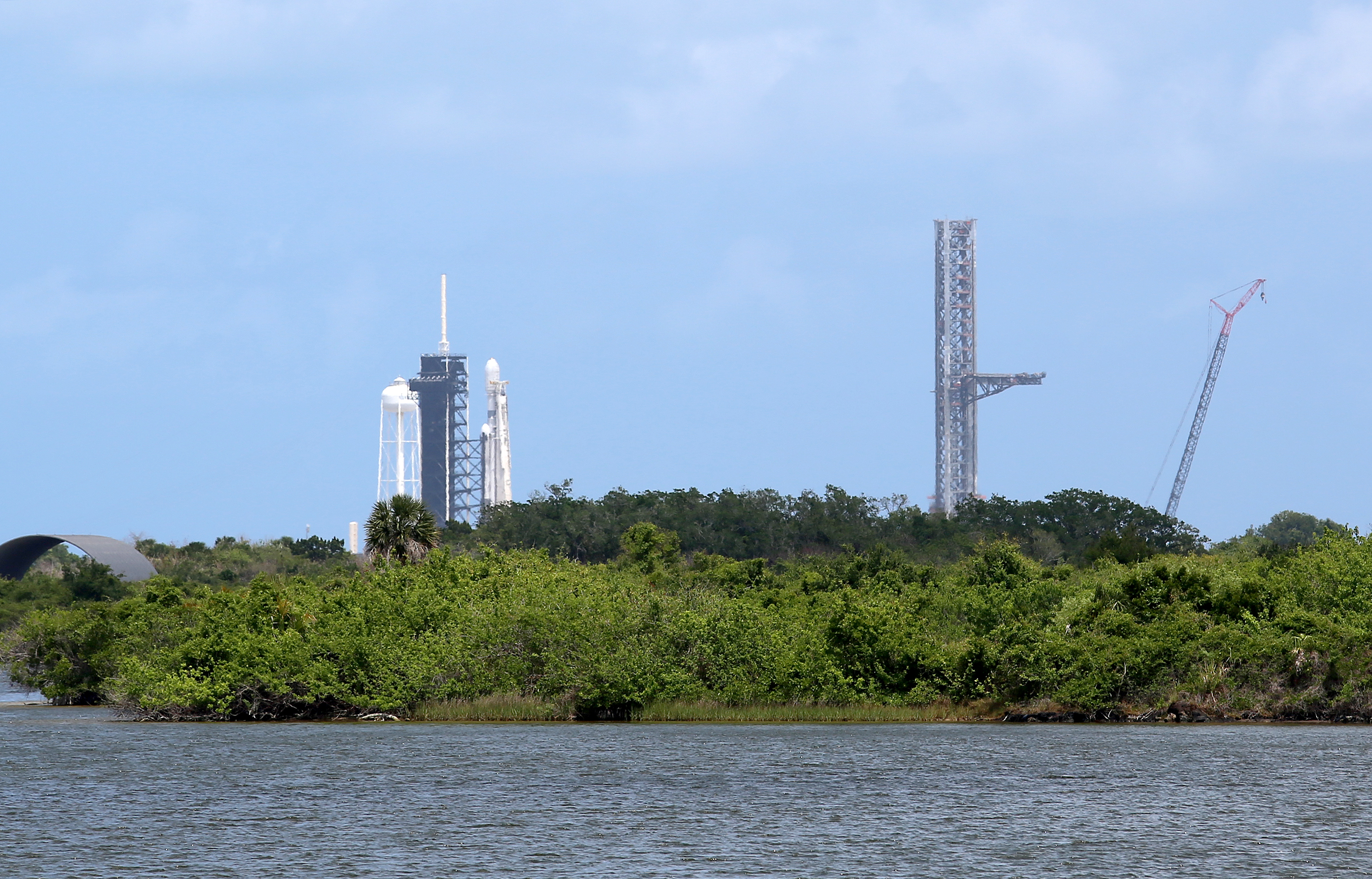 A SpaceX Falcon Heavy rocket, left, sits at Kennedy Space...