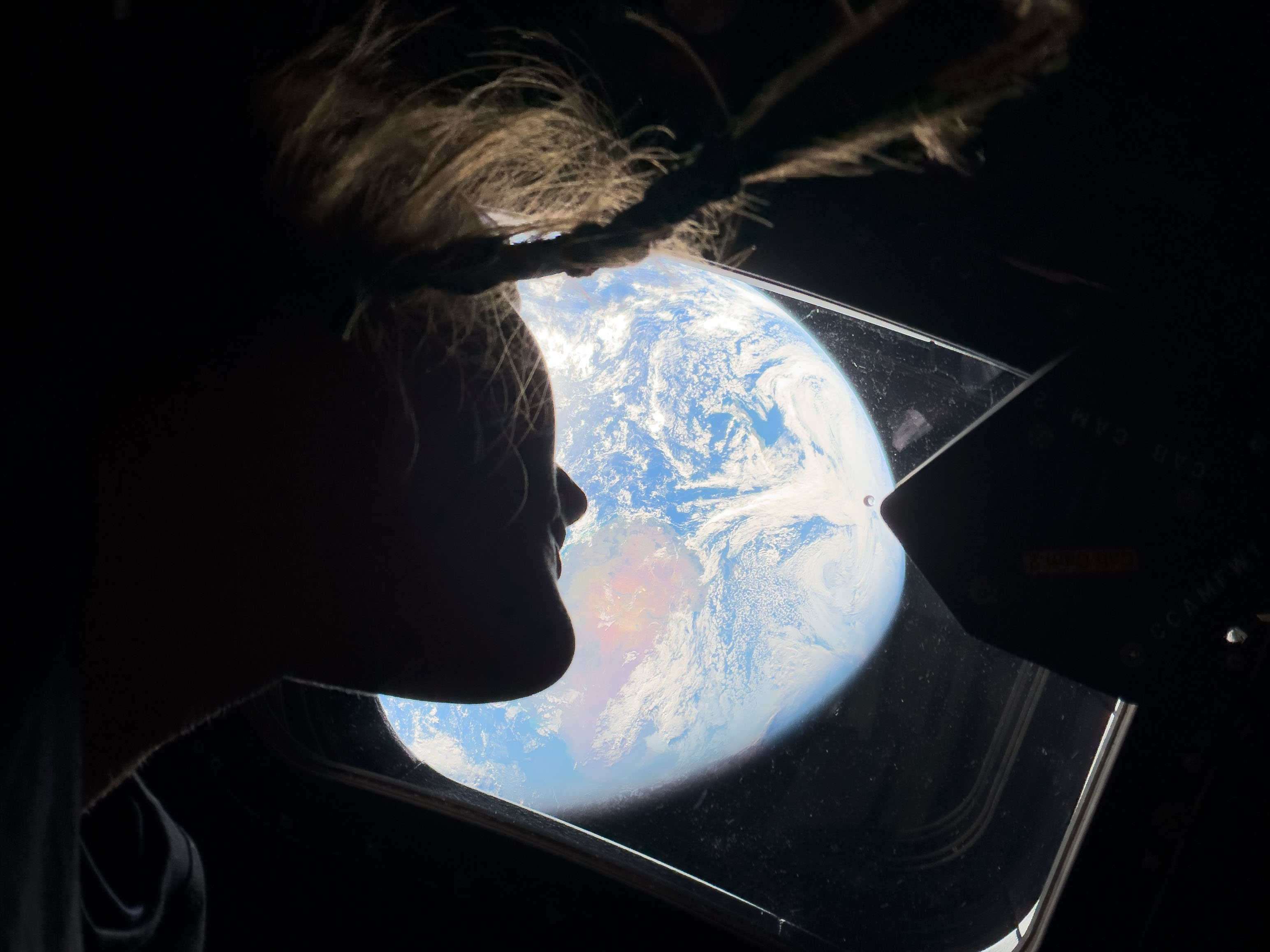 NASA astronaut and Artemis II mission specialist Christina Koch peers...
