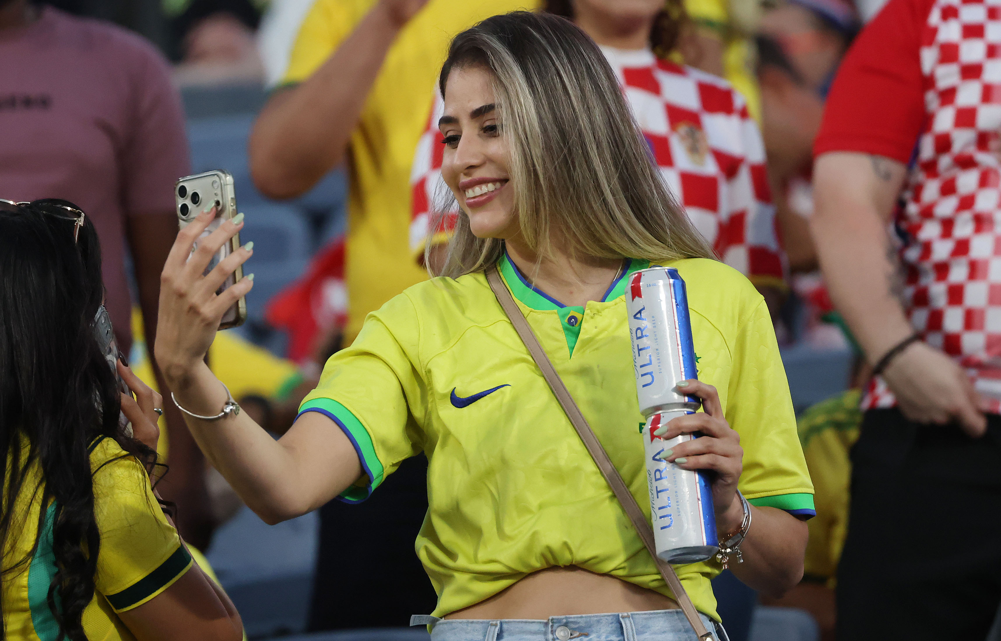 A Brazil fan holds two beers during the Brazil vs....