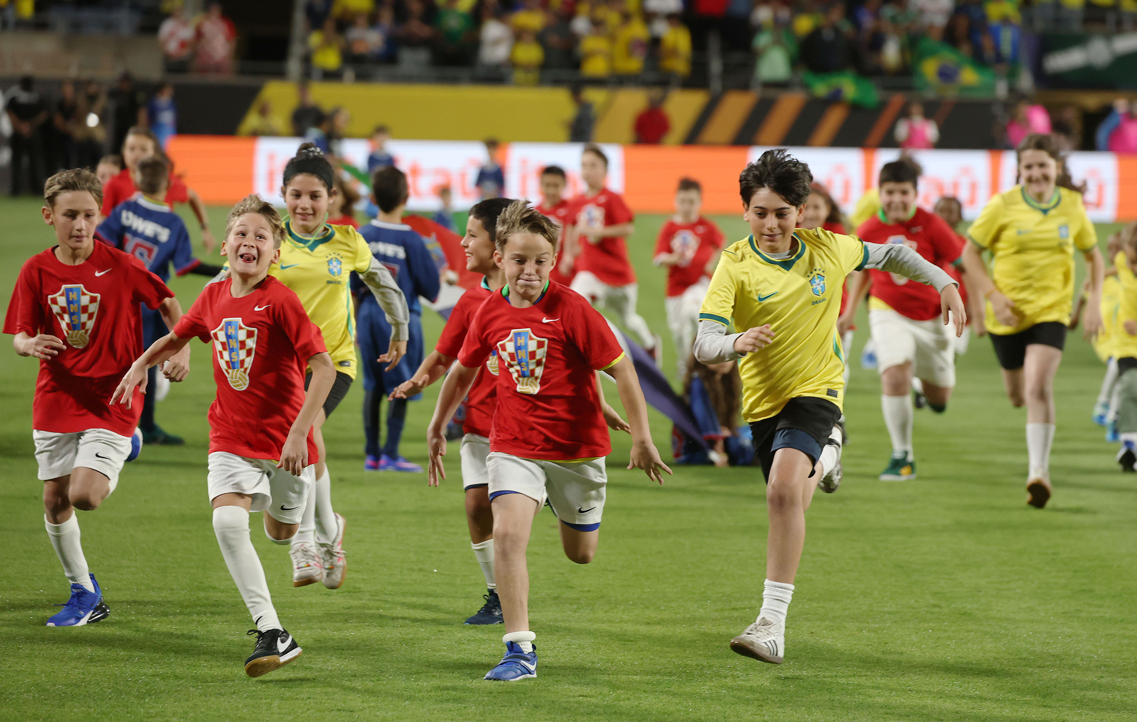 Kids run off the pitch during prematch festivities before the...